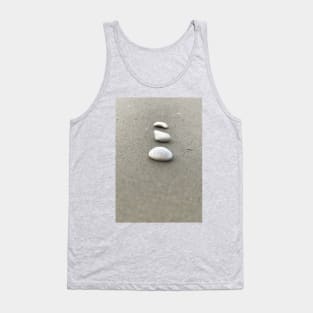 Simple closeup view of vertically arranged three white stones on grey sandy beach Tank Top